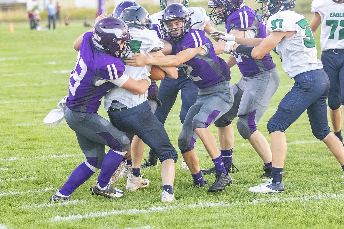 A swarming Charlo Viking defense smothers the Eagle running back for a loss.