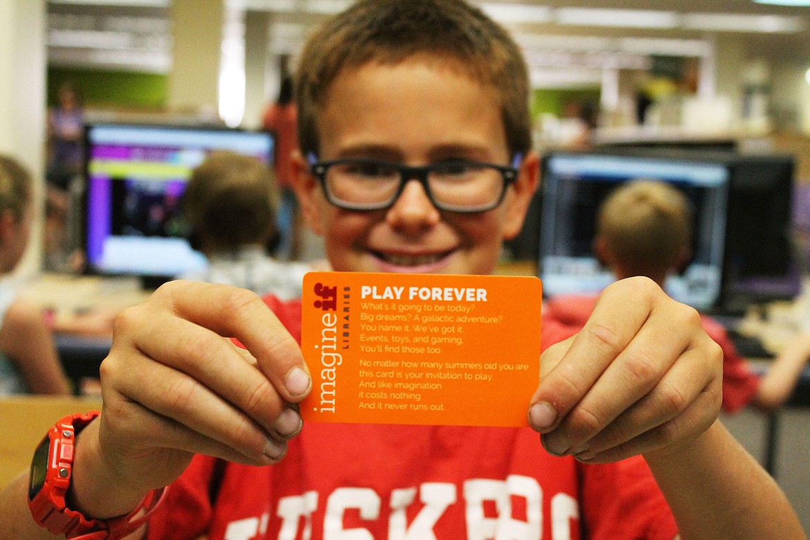 A young ImagineIF patron shows his new library card. September is natonal Library Card Sign-Up Month.