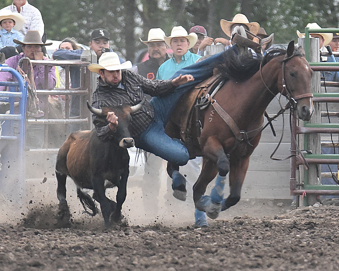 Kash Shade comes off his horse to grapple with his bovine opponent. With incredible strength, Kash put his steer down for the count to win the steer wrestling competition. (Marla Hall/Lake County Leader)