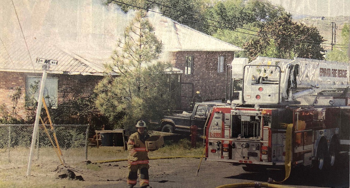 Grant County Fire District 7 Chief Kirk Sheppard carries a box of kittens away from a home fire in Soap Lake on May 15, 2012.