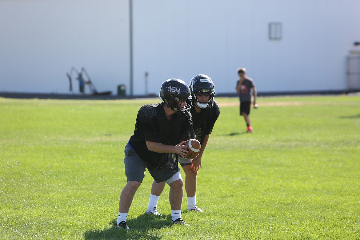 Sophomore quarterback Carter Pitts hands the ball off to teammate Grayson Beal during practice.