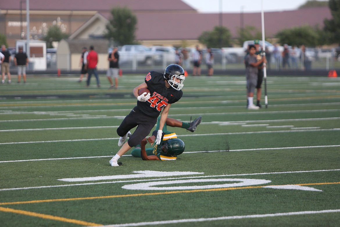 An Ephrata running back pushes off a Quincy defender to advance the ball upfield.