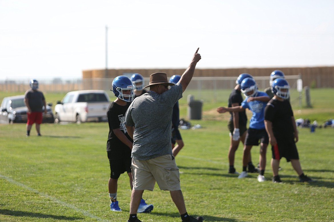 Head coach Robert Arredondo takes the opportunity to show his players the way to run a certain play during practice.