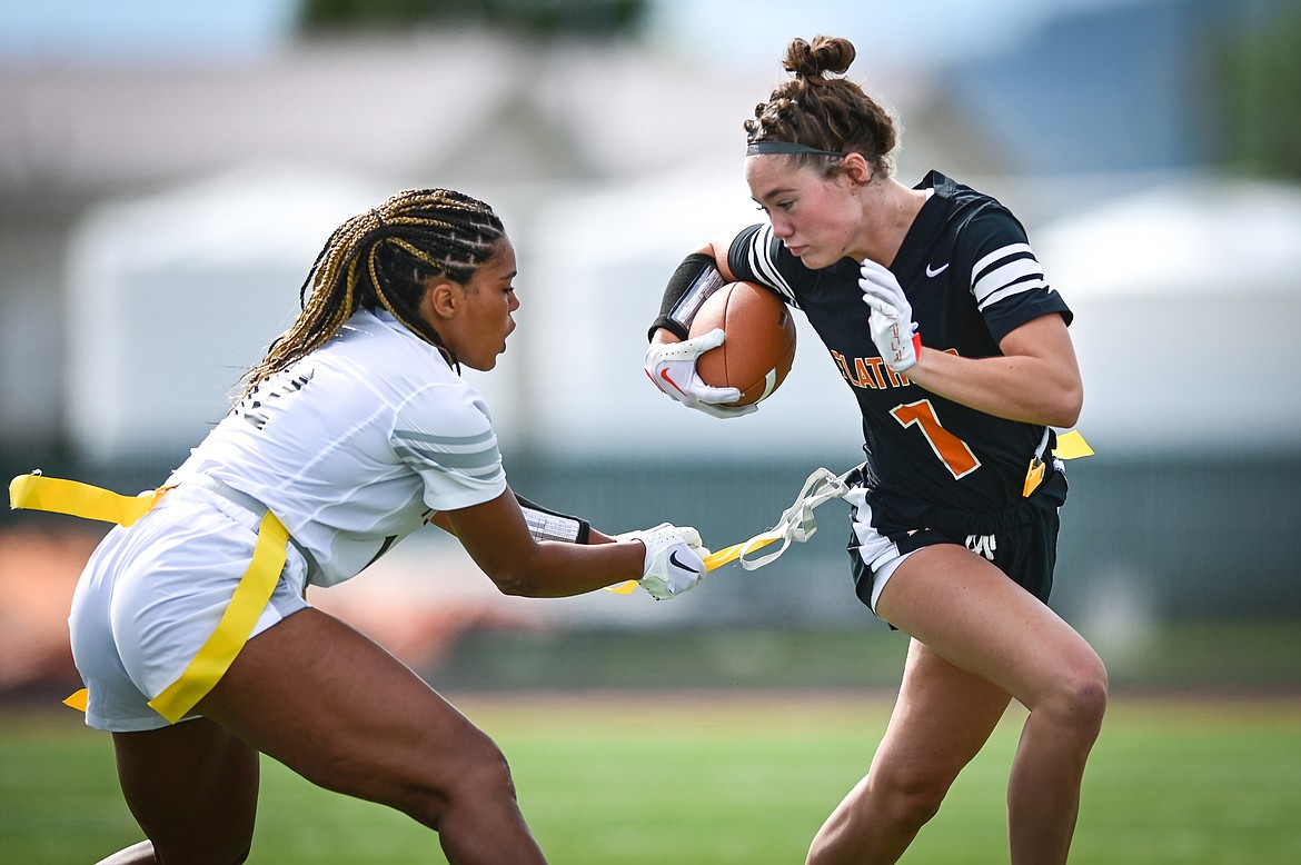 Akilah Kubi (12), left, tackles Peyton Walker (1) during a Flathead flag football scrimmage at Legends Stadium on Saturday, Aug. 27. (Casey Kreider/Daily Inter Lake)