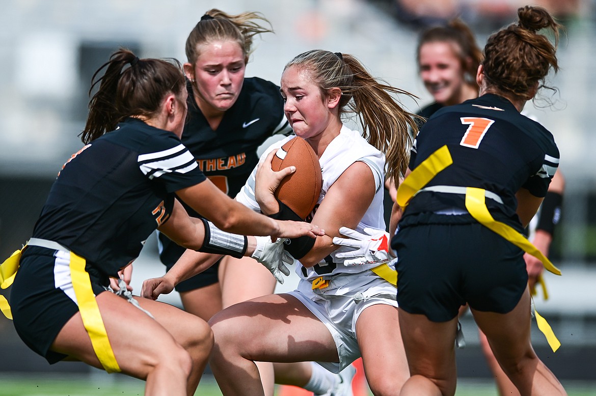 Quinlenn Tennison (13), center, tries to run through a group of defenders during a Flathead Flag Football scrimmage at Legends Stadium on Saturday, Aug. 27. (Casey Kreider/Daily Inter Lake)