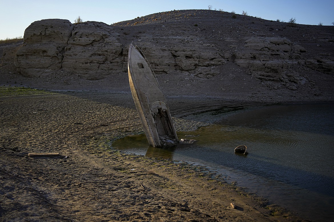 FILE - A formerly sunken boat sits upright into the air with its stern stuck in the mud along the shoreline of Lake Mead at the Lake Mead National Recreation Area, Friday, June 10, 2022, near Boulder City, Nev. The identification of bones found in May on the receding shoreline of Lake Mead has resurfaced family memories of a 42-year-old Las Vegas father believed to have drowned 20 years ago. (AP Photo/John Locher, File)