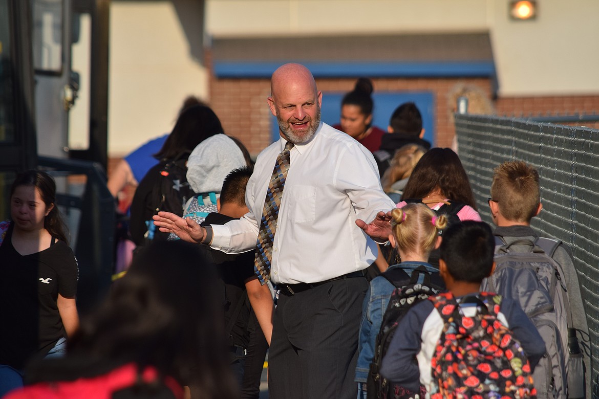 Warden School District Superintendent Scott West give high fives students near the school bus drop-off area during the first day of 2022-23 school year classes for Warden students on Wednesday.