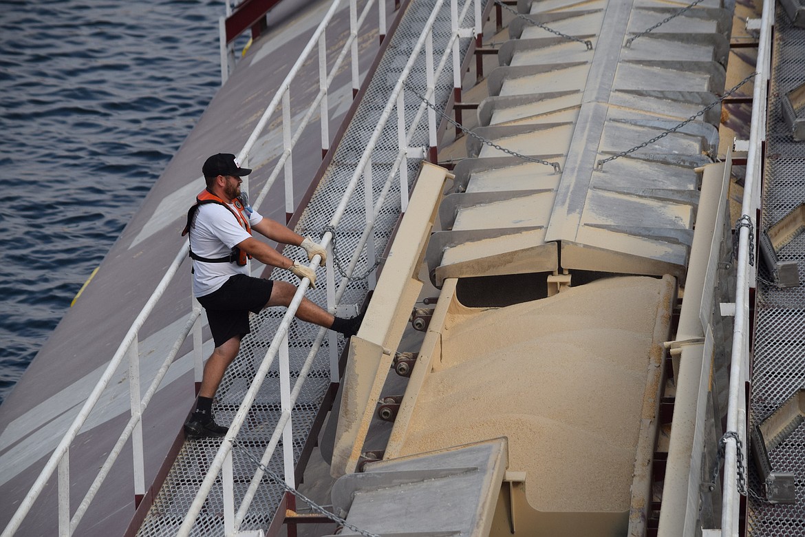 Deckhand Harold Lively kicks the lid of a grain bin closed as the tugboat Lincoln prepares to leave the Pomeroy Grain Growers terminal in Central Ferry.