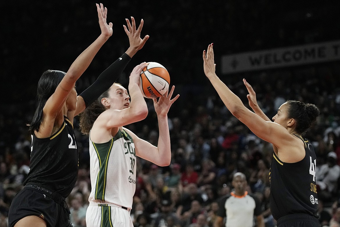 Seattle Storm forward Breanna Stewart (30) shoots against Las Vegas Aces forward A'ja Wilson, left, and center Kiah Stokes, right, during the second half in Game 1 of a WNBA basketball semifinal playoff series Sunday, Aug. 28, 2022, in Las Vegas.
