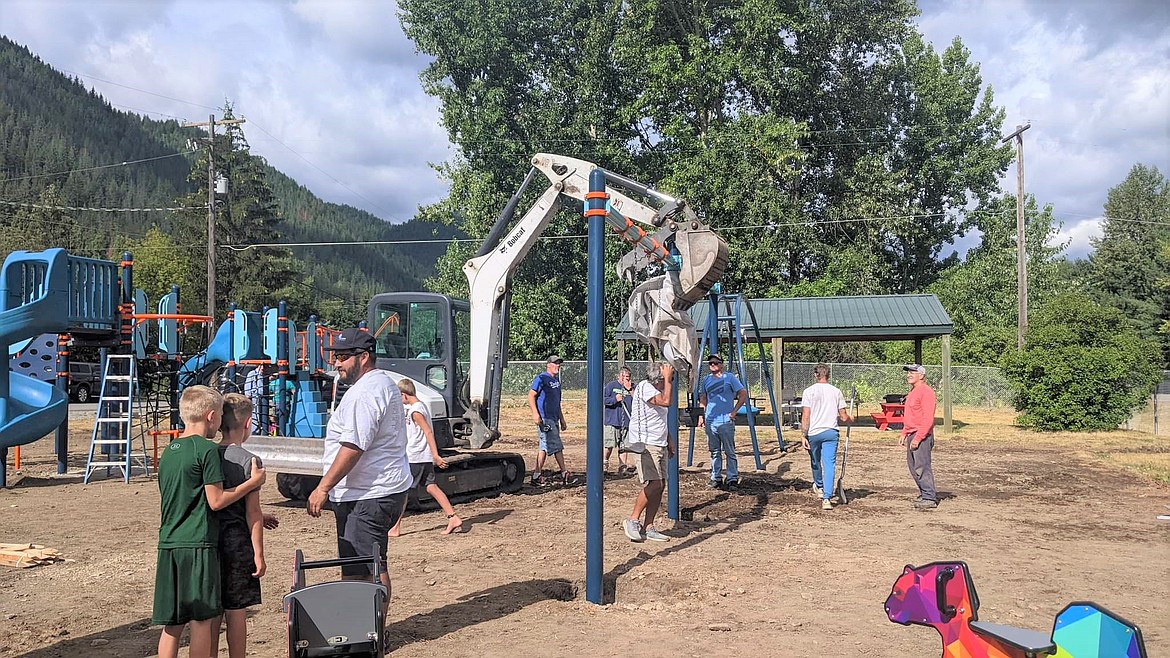 A Bobcat was used to stabilize the swing set during the community build.