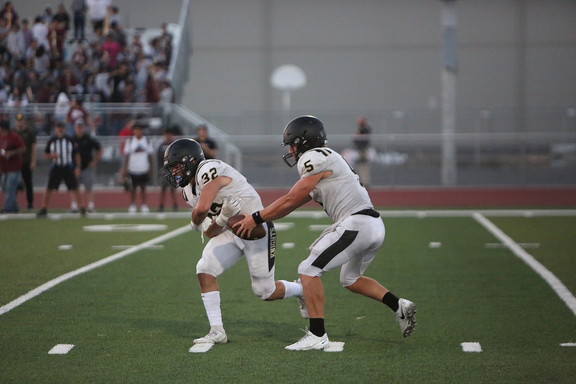 Royal quarterback Dylan Allred (5) fakes the handoff to running back Kaleb Hernandez (32) during Royal’s 34-6 win over Toppenish.