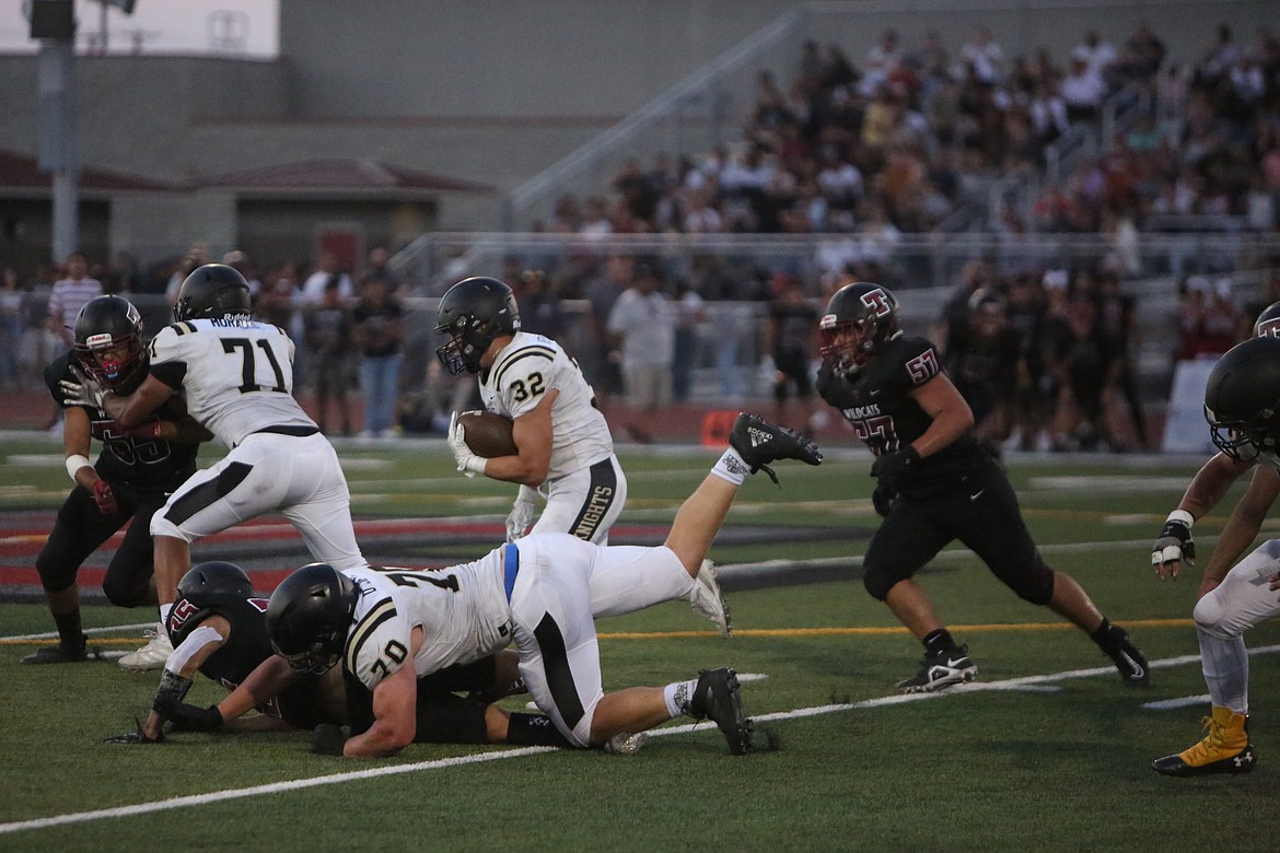 Senior running back Kaleb Hernandez (32) cuts upfield following a pancake block by offensive lineman Detton Jenks (70).