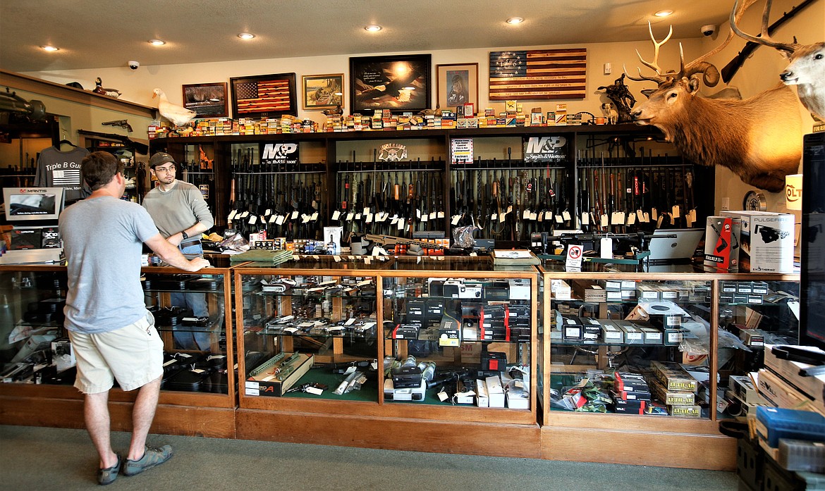 Logan Boyle waits on a customer at Triple B Guns on Friday.