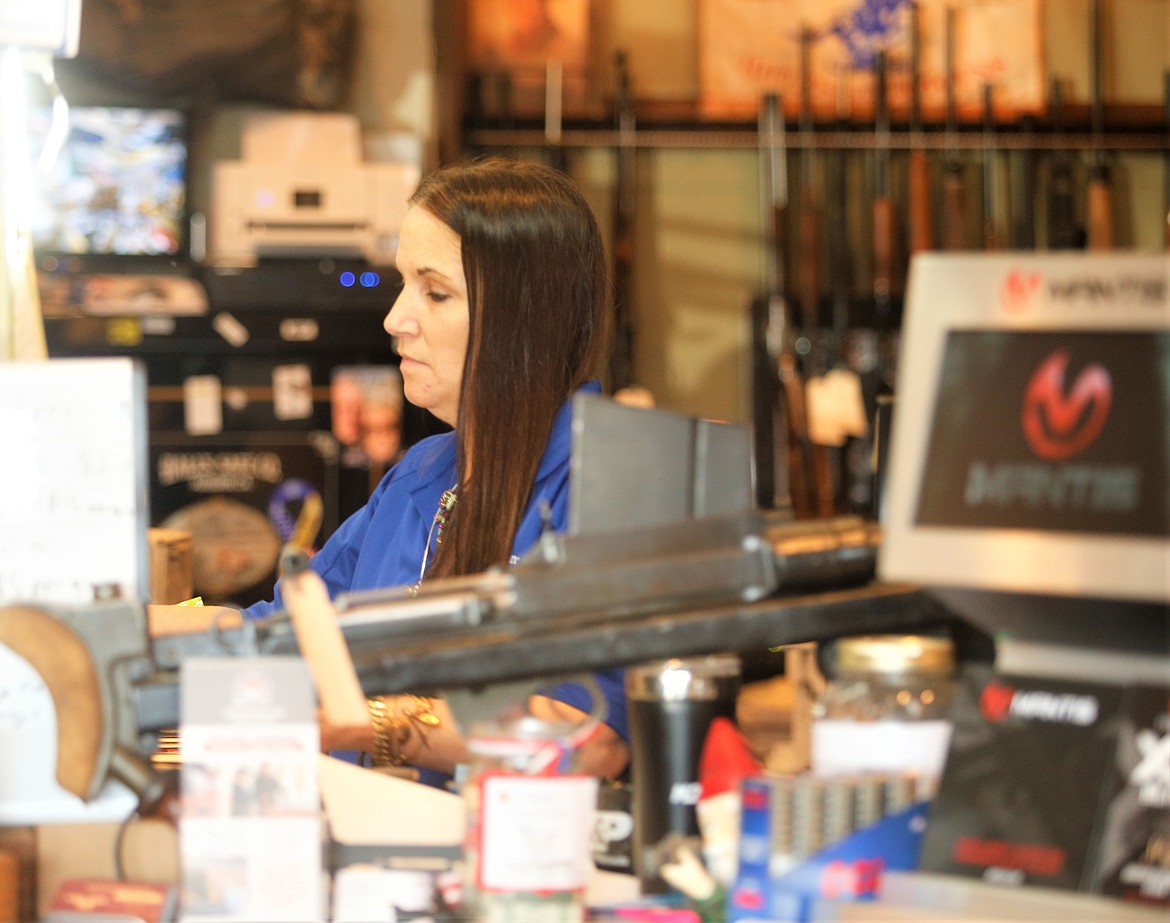 Kinsey Boyle rings up a sale at Triple B Guns on Friday.