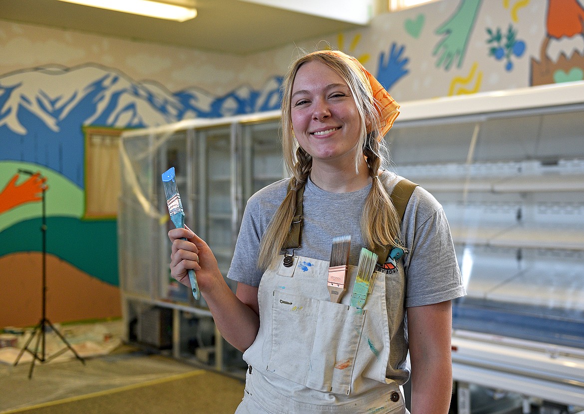Artist Alyssa Shaw, owner of Hikingbird Creative, recently paints the mural she designed on the walls of North Valley Food Bank. (Whitney England/Whitefish Pilot)