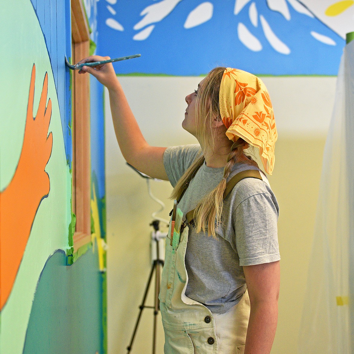 Artist Alyssa Shaw, owner of Hikingbird Creative, recently paints the mural she designed on the walls of North Valley Food Bank (Whitney England/Whitefish Pilot)