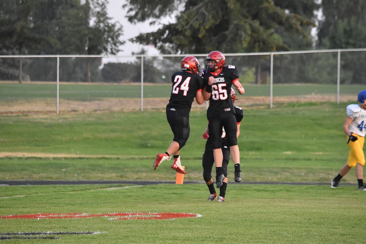 Lind-Ritzville juniors Brock Kinch, 24, and Shawn Steinberger, 65, celebrate a touchdown by Kinch.