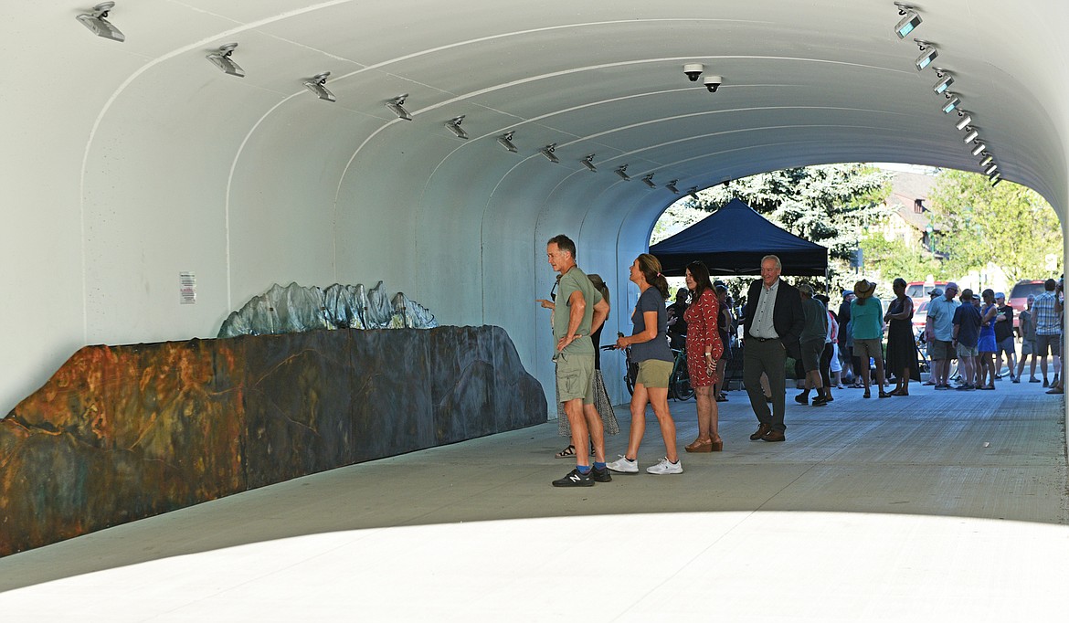 People view the new public art in the Baker Avenue underpass last week during the ribbon cutting ceremony. (Julie Engler/Whitefish Pilot)