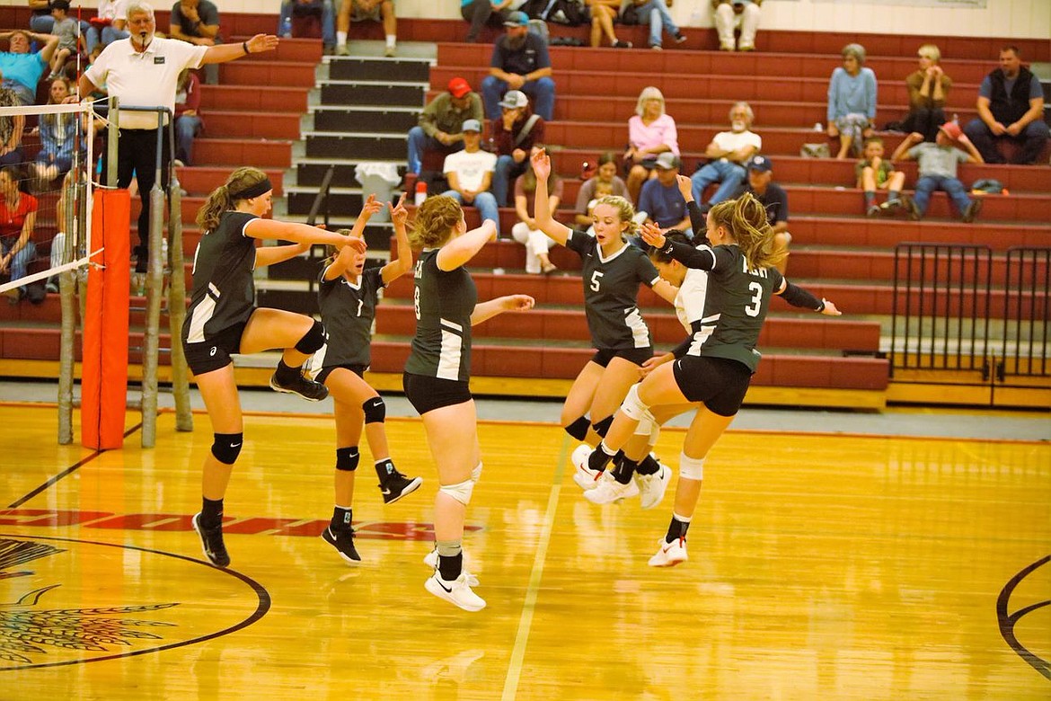 Warrior volleyball players celebrate during their matchup against Waterville-Mansfield Tuesday evening.