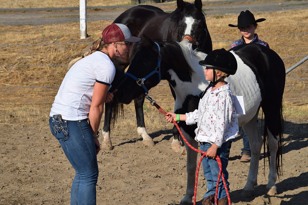 Equestrian Judge Kathryn Holden speaks with Hanna Giesen after the fitting and showing competition during the Wheat Land Communities’ Fair in Ritzville on Friday. “Horses are my life,” said Holden, who also runs barrel races. “I can’t think of a better connection you could have with a 1,200-pound animal.”