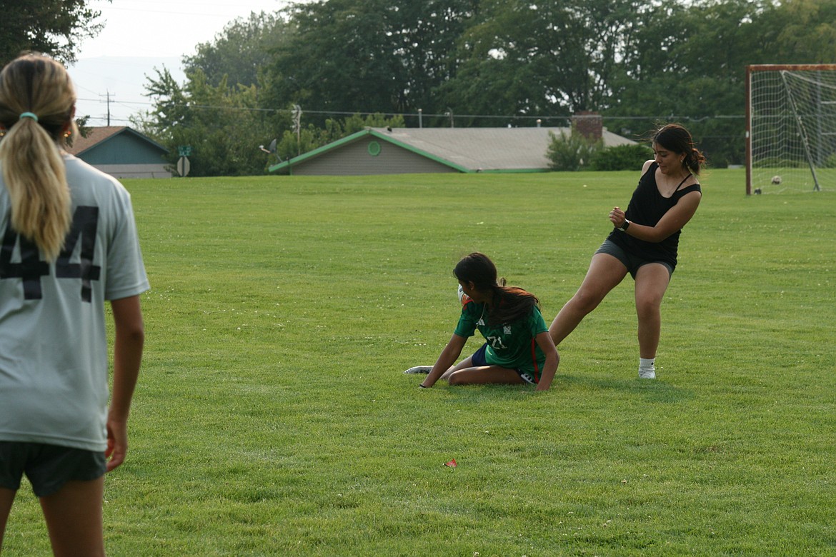 Rubi Mondragon, foreground, goes low to intercept the ball during soccer practice at Othello High School Friday.