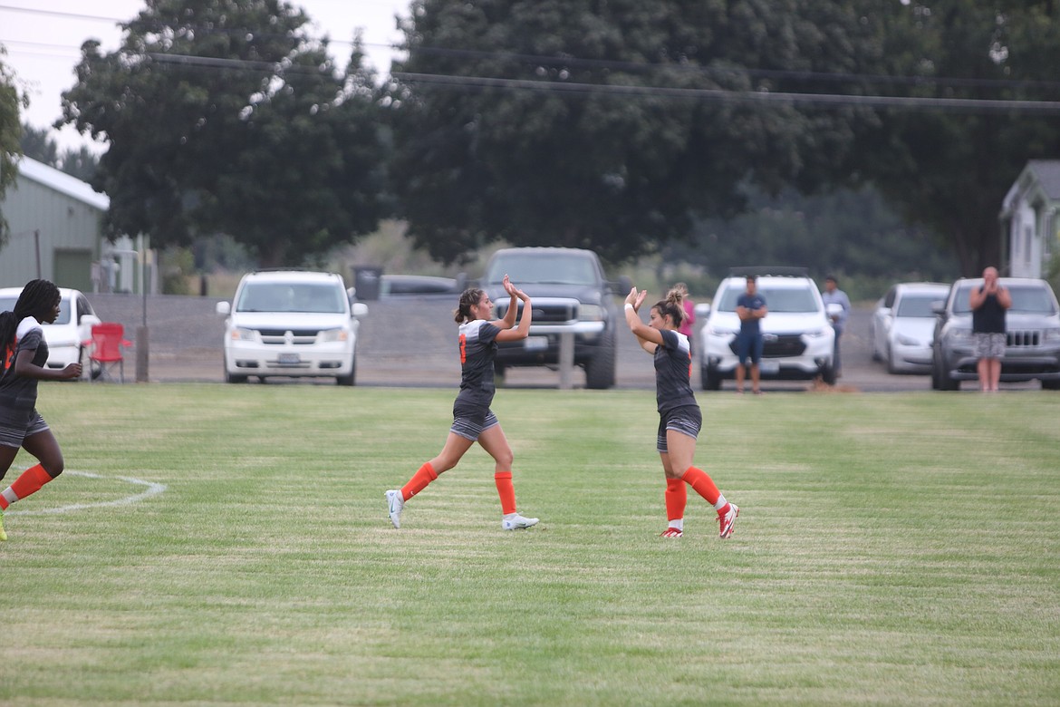 Ephrata teammates Aliya Avila, left, and Kadence Hector, right, high-five after scoring a goal in the Tiger’s season-opening win over Cascade (Leavenworth).