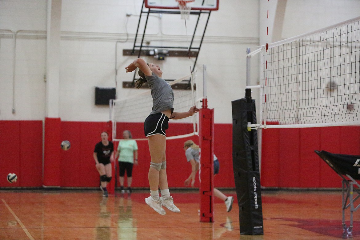 Senior Zoe Galbreath jumps in the air to return a ball over the net.