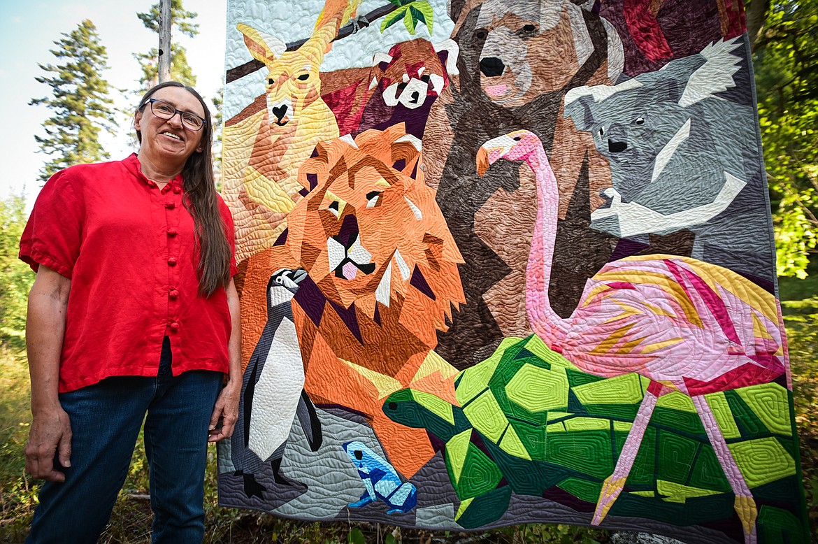 Cathy Calloway stands with her quilt titled "The Menagerie" outside her residence in Creston on Wednesday, Sept. 7. (Casey Kreider/Daily Inter Lake)