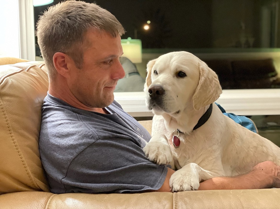 “Two Goofy Dogs” author Denver Morford relaxes with his English cream golden retriever Harry.