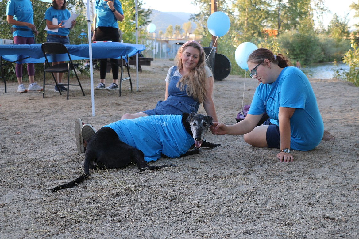 Two participants — and their canine companion — rest at an after-walk barbecue after Sunday's Walk for HOPE.