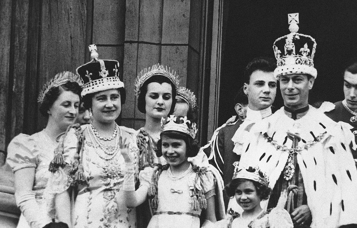 Princess Elizabeth, center, age 11, appears on the balcony of Buckingham Palace after the coronation of her father, King George VI, right, in London, May 12, 1937. Queen Elizabeth II, Britain’s longest-reigning monarch and a rock of stability across much of a turbulent century, has died. She was 96. Buckingham Palace made the announcement in a statement on Thursday Sept. 8, 2022. (AP Photo, File)