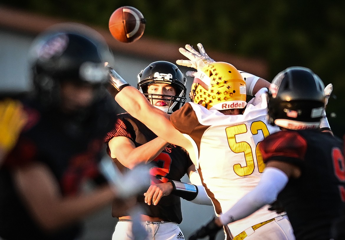 Flathead quarterback Jackson Walker (2) throws a screen pass to running back Joe Jones (9) under pressure from Helena Capital defensive lineman Talon Marsh (52) in the first half at Legends Stadium on Friday, Sept. 9. (Casey Kreider/Daily Inter Lake)