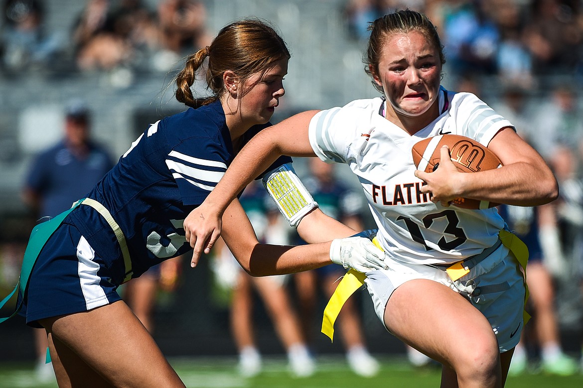 Flathead's Quinlenn Tennison (13) is tackled by Glacier's Macie Schreckengust (25) at Legends Stadium on Saturday, Sept. 10. (Casey Kreider/Daily Inter Lake)