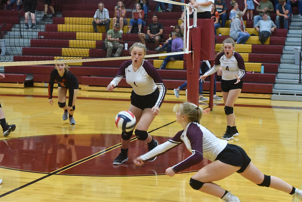 Troy Lady Trojans volleyball player Cortenie Rogers lunges for a ball as teammate Autumn Fisher (1) and Elaine Folkerts (4) react during a match against Plains on Thursday, Sept. 8. (Scott Shindledecker/The Western News)