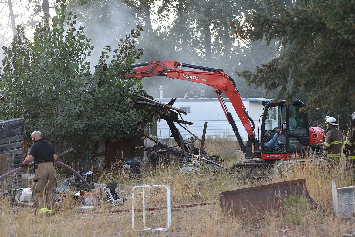 The Libby Volunteer Fire Department used an excavator to help battle a fire that destroyed a White Avenue residence just east of Libby on the evening of Friday, Sept. 9. (Scott Shindledecker/The Western News)