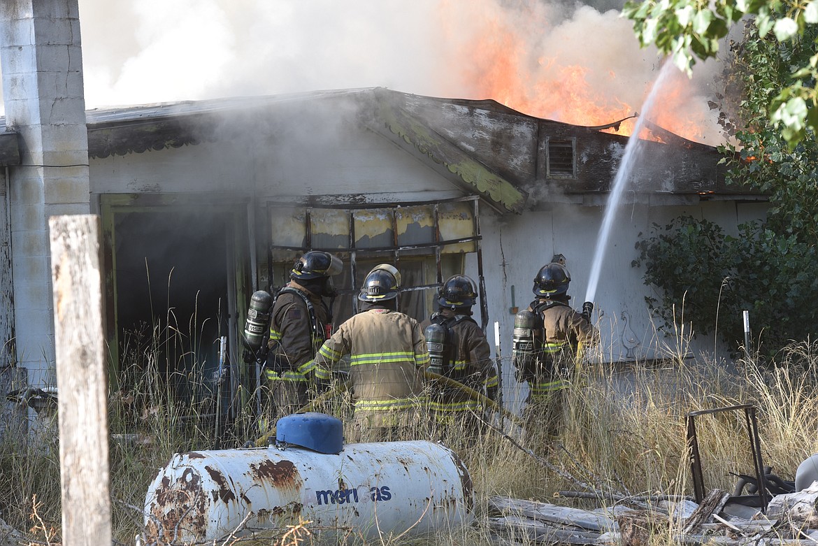 Libby Volunteer Fire Department firefighters battle a blaze that destroyed a White Avenue residence just east of Libby on the evening of Friday, Sept. 9. (Scott Shindledecker/The Western News)