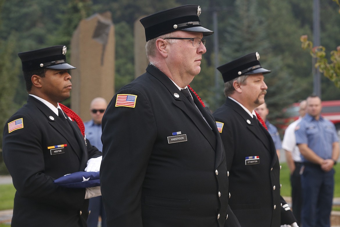 From left, Coeur d’Alene Fire Department honor guard members Joshua Hoston, Robert Anderson and Craig Etherton conducted a flag ceremony at the Fallen Heroes Memorial Plaza to honor those who died in the 9/11 attacks.