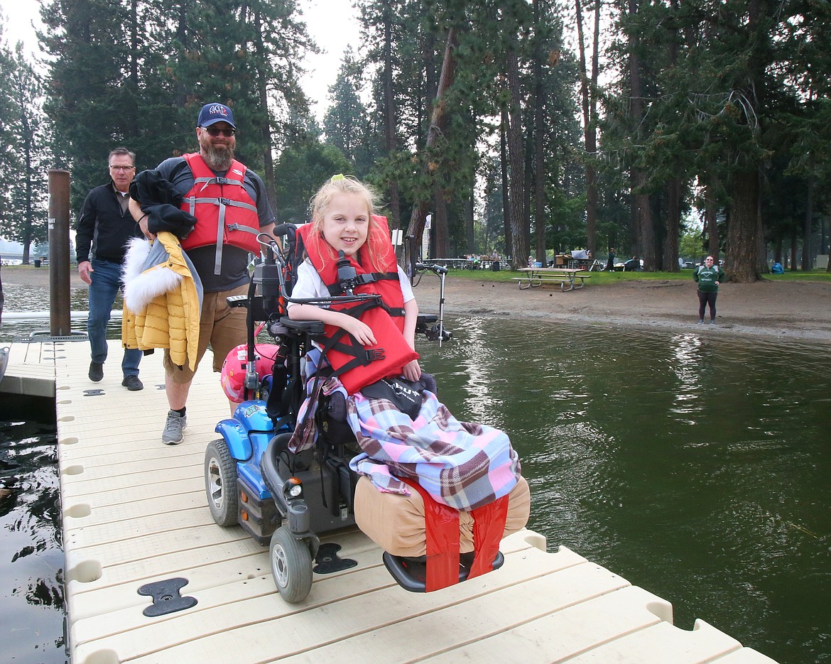 Tracy Sams, 9, of Rathdrum cruises along the Q'emiln Park Boat Launch dock followed by her dad Trever Sams after a C.A.S.T. for Kids fishing excursion Sunday morning on the Spokane River.