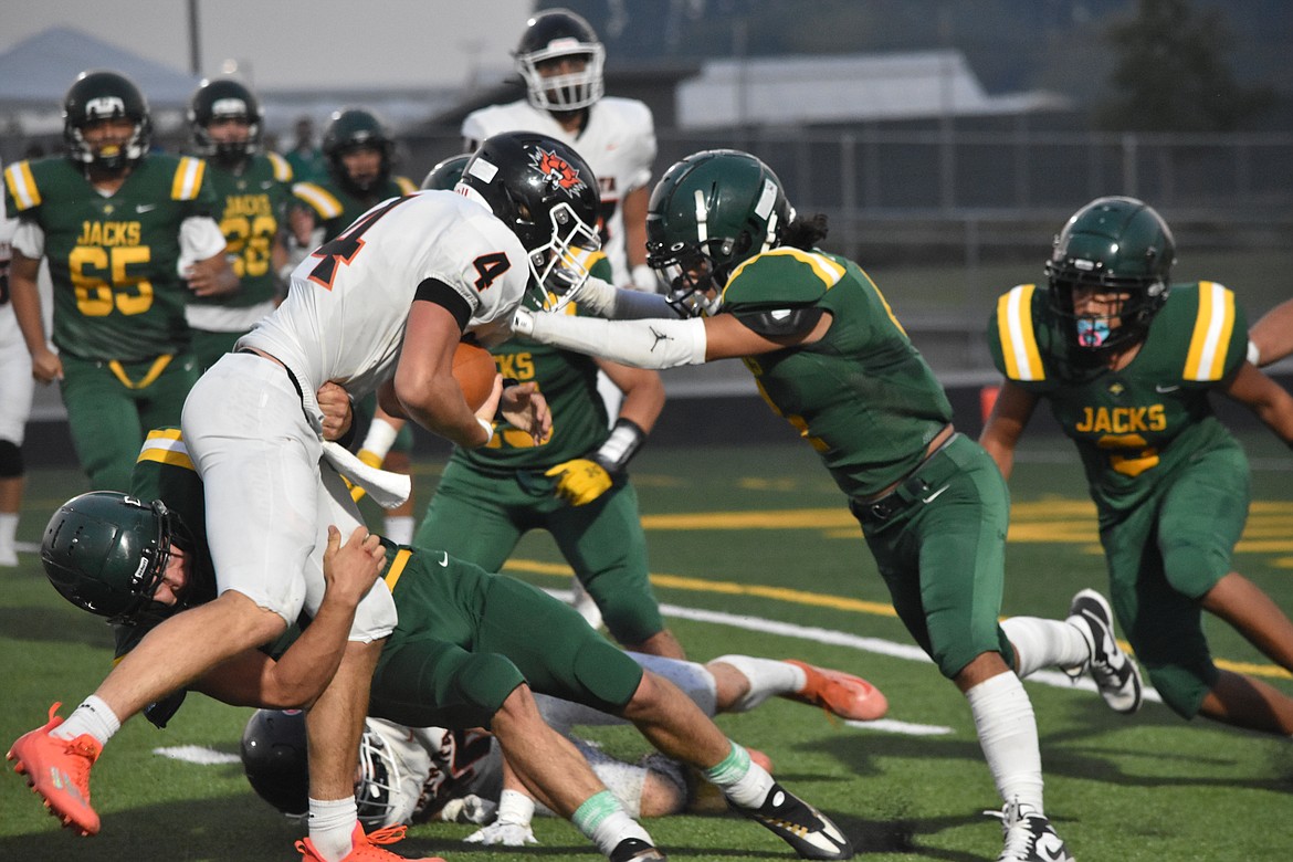 Two Quincy players tackle a rushing Ephrata player at Quincy High School Friday night.