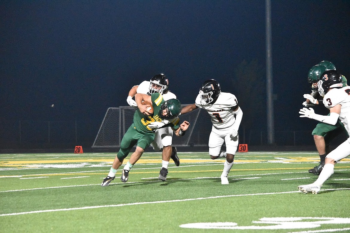 Quincy’s Kenny Thompson (33) fights to gain extra yards through two Ephrata defenders.