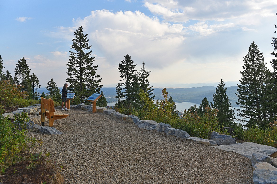 A visitor reads informative signs on one of the tiered viewing areas at the new Holbrook Trailhead. (Julie Engler/Whitefish Pilot)