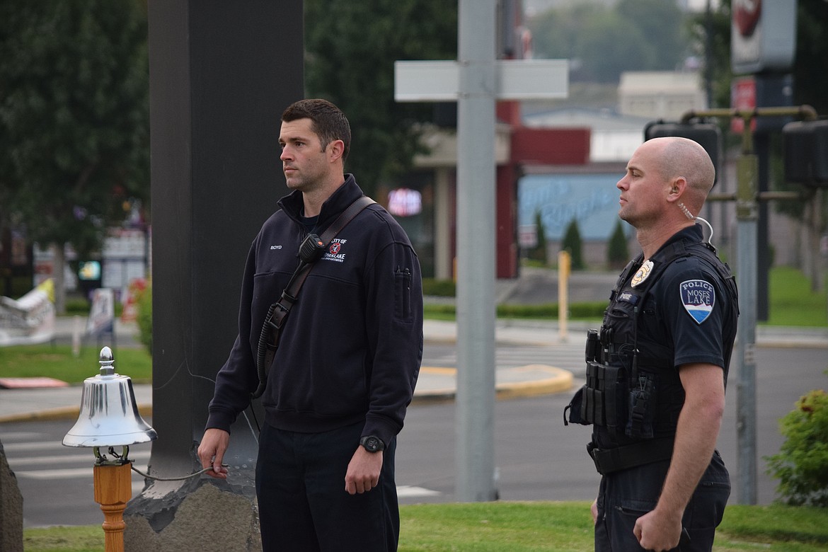 Moses Lake Fire Department firefighter Dustin Boyd and Moses Lake Police Department officer Caleb Welsh mark a moment of silence at the city’s 9/11 Memorial during a short service of remembrance Sunday morning.