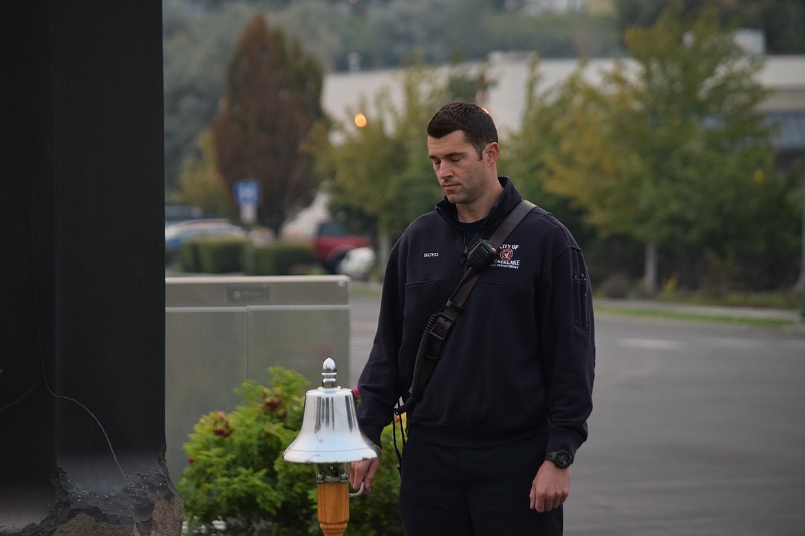 Moses Lake Fire Department firefighter Dustin Boyd and Moses Lake Police Department officer Caleb Welsh mark a moment of silence at the city’s 9/11 Memorial during a short service of remembrance Sunday morning.