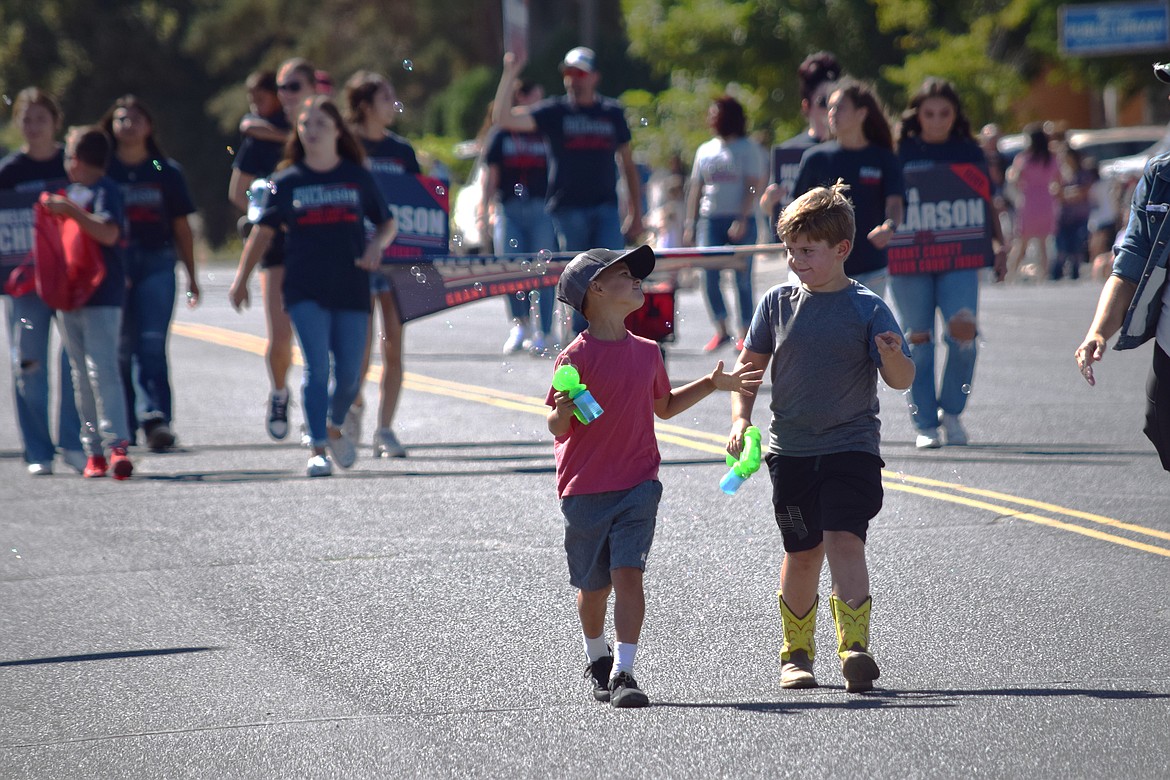 A pair of boys with soap bubble guns march up Main Avenue in downtown Warden during the 2022 Warden Community Days Parade on Sept. 5.