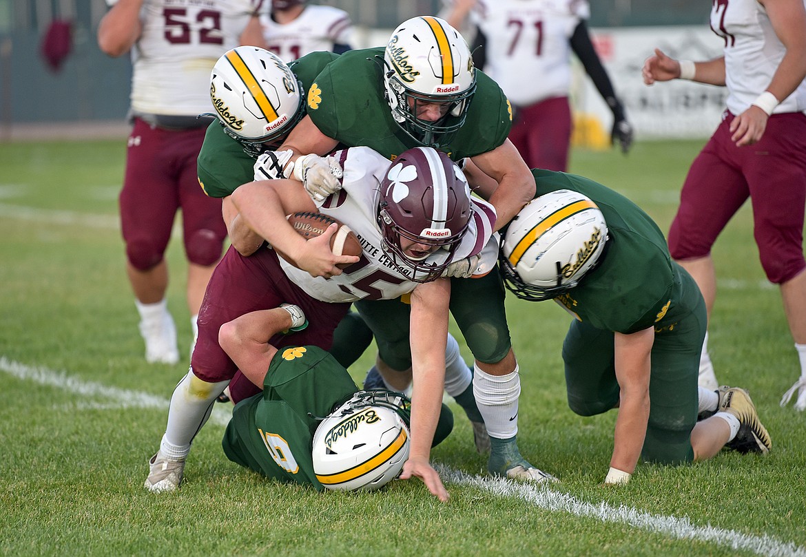 Multiple Bulldogs take down a Butte Central player for a loss of yards in a game on Friday in Whitefish. (Whitney England/Whitefish Pilot)