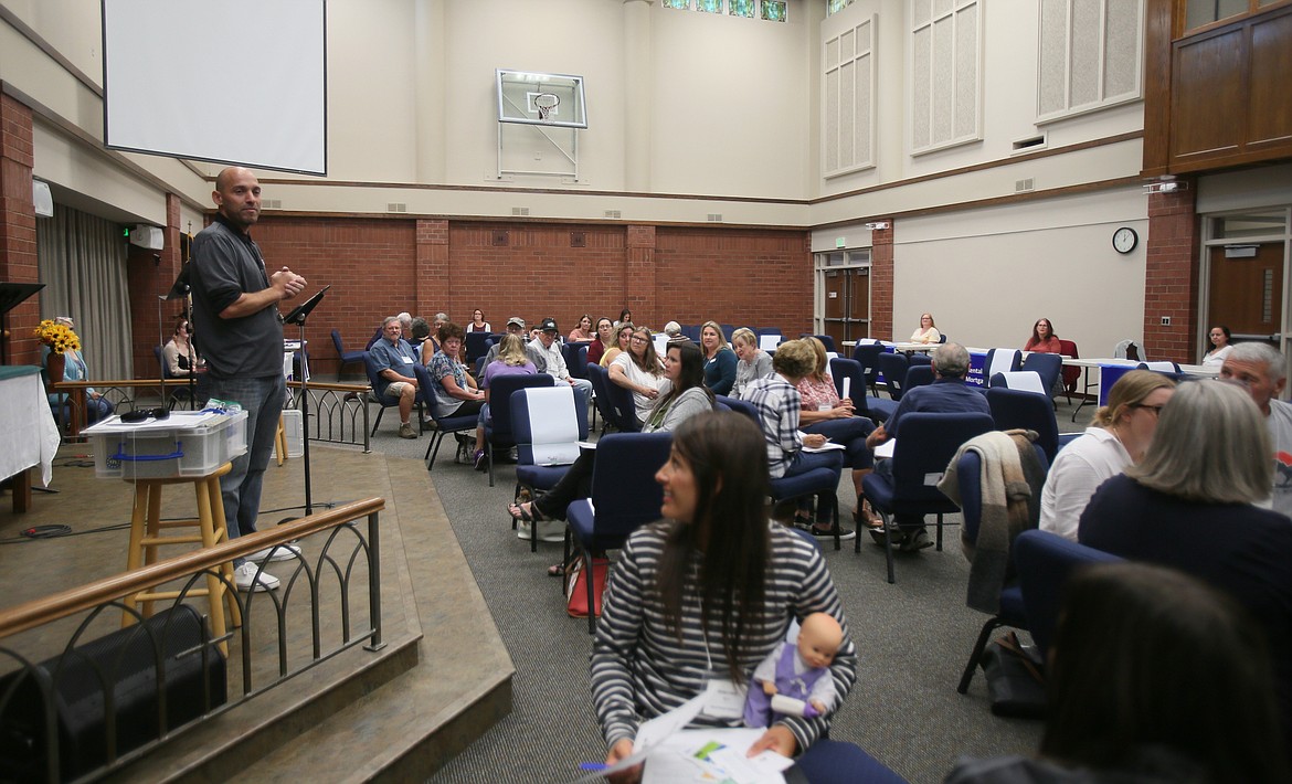 Cost of Poverty Experience coordinator Jesse Quintana of Community Action Partnership speaks to participants Tuesday as they navigate poverty scenarios taken from real life.