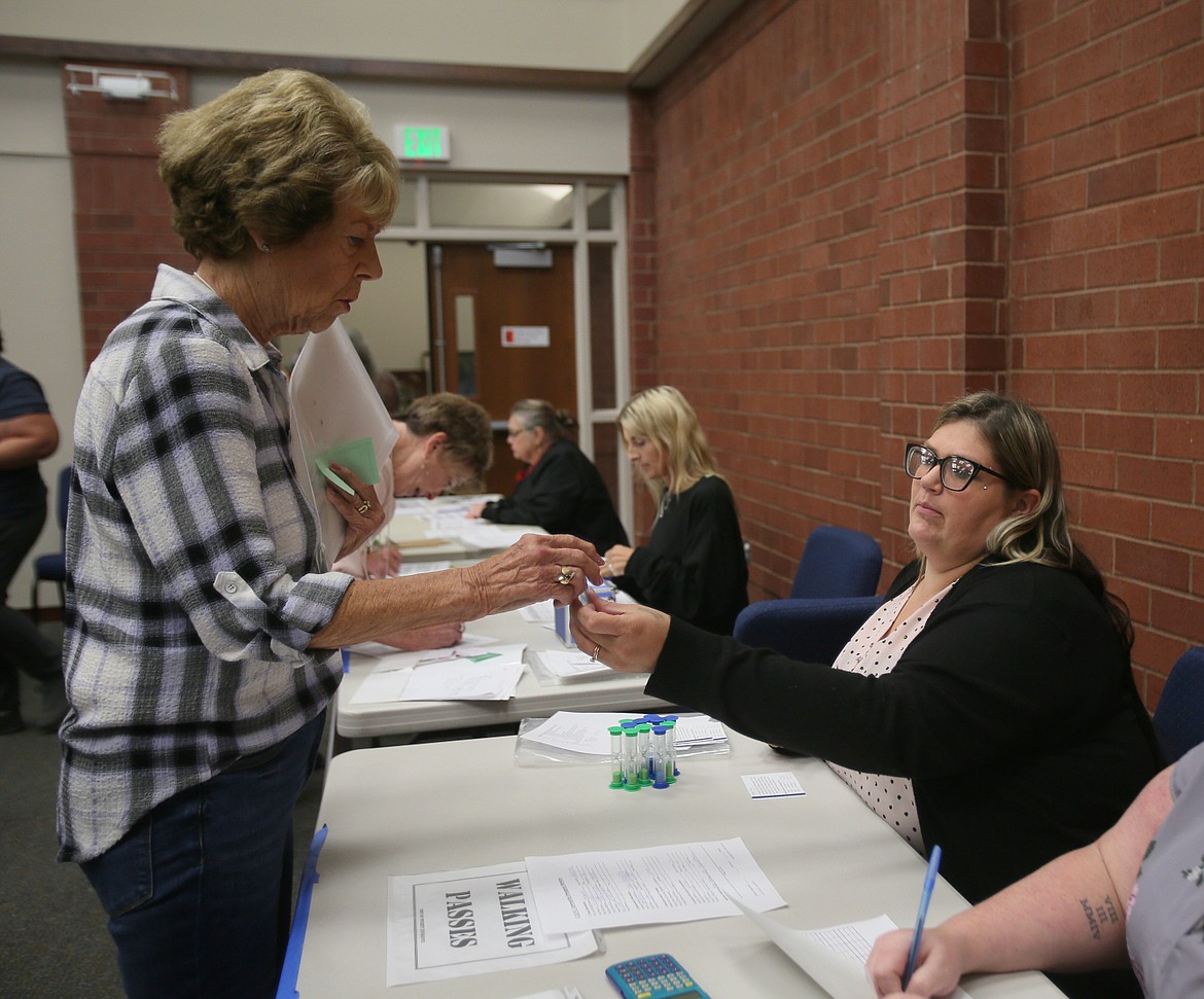 Jennifer Struckman, seated, hands Dianne Reimer an egg timer to represent the time it takes people to walk to accomplish tasks as they navigate homelessness. About 50 people participated in Community Action Partnership's poverty simulation Tuesday.