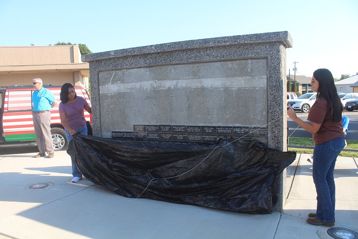 Elizabeth Arroyo and Eylin Arroyo reveal the new names added to the Quincy Valley Veterans Recognition Wall Saturday. The two were attending the event and were asked to do the honors.