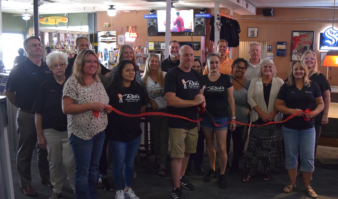 Rick Biery, the owner of Rick’s Eatery and Entertainment at 819 W. Third Ave. in Moses Lake, formally cuts the ribbon with employees Kari Chapman (right), Linda Garcia (left) and members of the Moses Lake Chamber of Commerce to celebrate the opening of the bar and restaurant formerly known as The Hang Out.