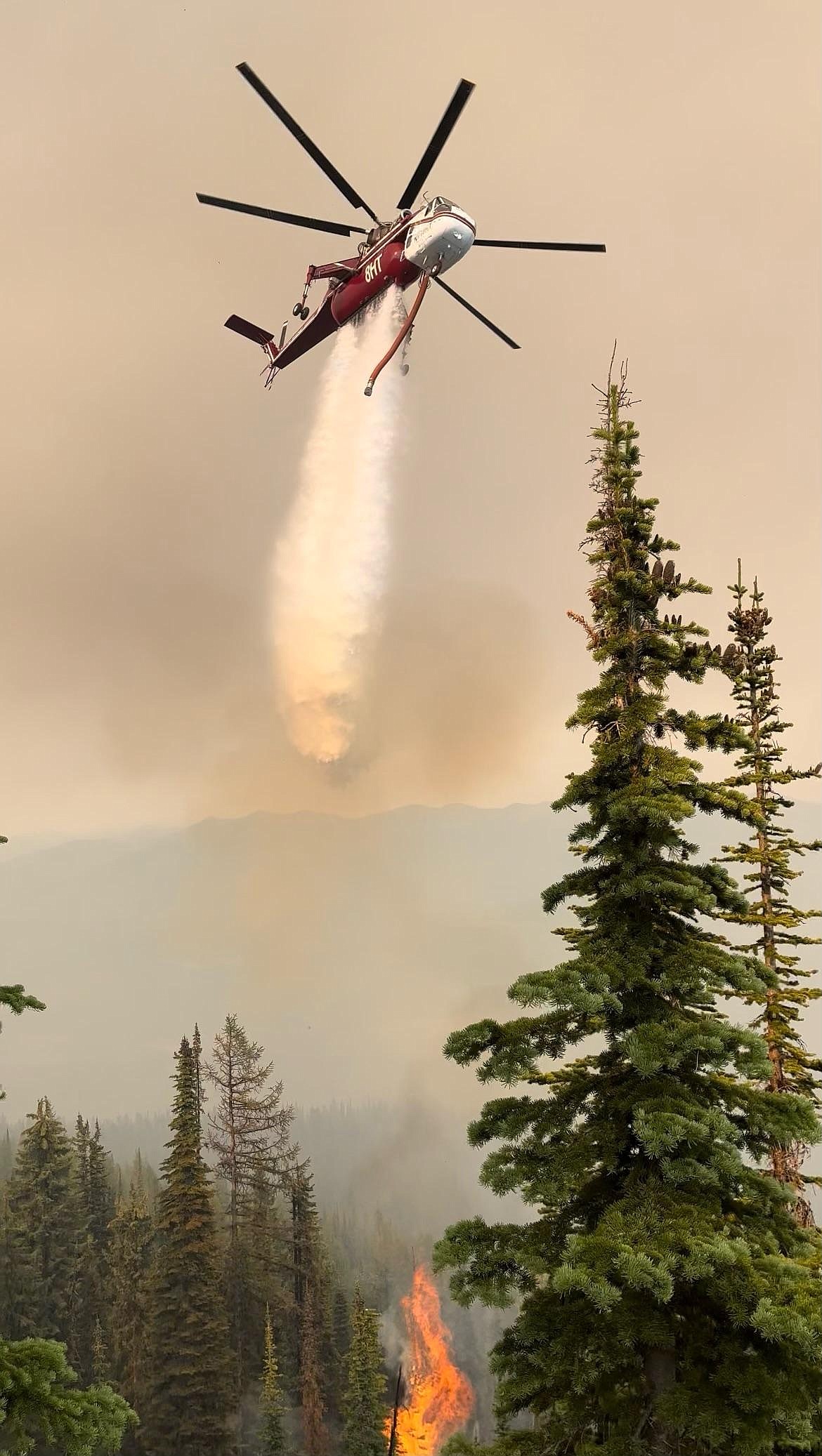 A Type 1 Skycrane helicopter drops water on the Katka fire during the initial attack on the blaze.